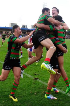 Souths players mob Alex Johnston after scoring a try - the rookie ended the match with a hat trick. 