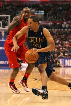 Andre Miller of the Denver Nuggets dribbles to the basket past Jamal Crawford of the Los Angeles Clippers.