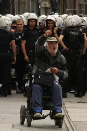 "Spray me if you have to": A wheelchair-bound protester confronts the police.
