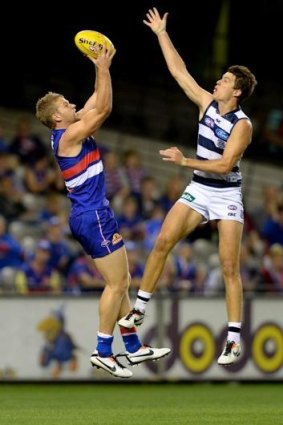 Bulldog Jake Stringer (left), seen taking a mark ahead of Geelong's Andrew Mackie last year, is one recent draftee who has benefited from exposure to VFL football in his draft season.