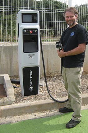 Chris Jones at an electric vehicle charging station.