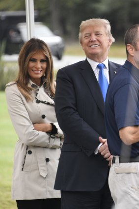 U.S. President Donald Trump, center, and U.S. First Lady Melania Trump smile while talking with an employee at a tour of the U.S. Secret Service James J. Rowley Training Center in Beltsville, Maryland, U.S., on Friday, Oct. 13, 2017. After months of pinning the blame for Obamacare's shortcomings on Democrats and watching his own party fail to act, Trump?took ownership of a struggle that's consumed Republicans for seven years. Photographer: Ron Sachs/Pool via Bloomberg