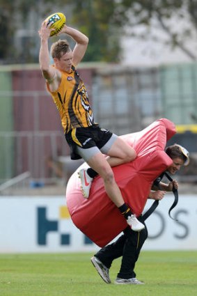 Back-breaker: Richmond coach Damien Hardwick gets down to business at training with high-flyer Jack Riewoldt.
