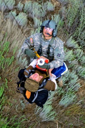A flight medic with the Colorado Air National Guard, carries an unidentified evacuee up a hoist onto a Black Hawk helicopter during flood rescue and recovery operations near Boulder. Military helicopter crews have flown hundreds of missions to rescue about 2000 people.