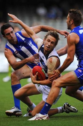 Caught: Geelong's Billie Smedts is tackled by Michael Firrito and Jamie MacMillan.