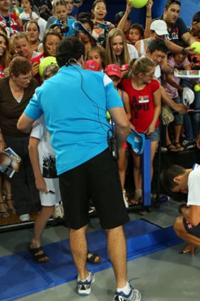 A corporate box facia gives way as spectators surge to get an autograph from Novak Djokovic of Serbia.