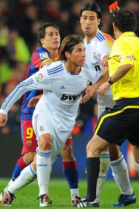 The referee shows a red card to Real Madrid's defender Sergio Ramos.