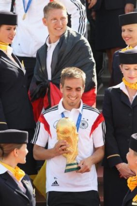 Germany's captain Philipp Lahm holds the World Cup trophy as the team arrives in Berlin on Tuesday.