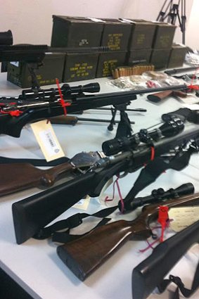 Police seized 13 firearms, nearly $18,000 in cash and several thousand rounds of ammunition in a raid on a Port Kennedy home over the weekend.