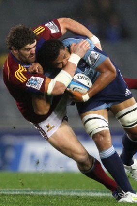 The Blues' Peter Saili is tackled by Jamie Mackintosh of the Highlanders.