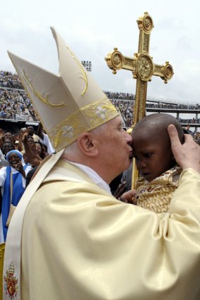 Isolated ... Pope Benedict XVI kisses a young girl as he leaves the Amadou Ahidjo stadium in Cameroon.