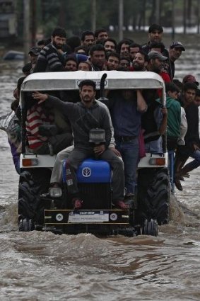 A tractor evacuating Kashmiri flood victims to higher ground travels through a flooded street in Srinagar.