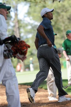 Tiger Woods of the US rushes to look after hitting from a rough on the 9th hole during the third round.