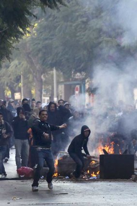 Demonstrators throw stones at police during clashes in Tunisia.
