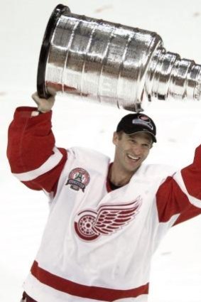 Dominik Hasek holds the Stanley Cup after the Detroit Red Wings beat Carolina Hurricanes in 2002.