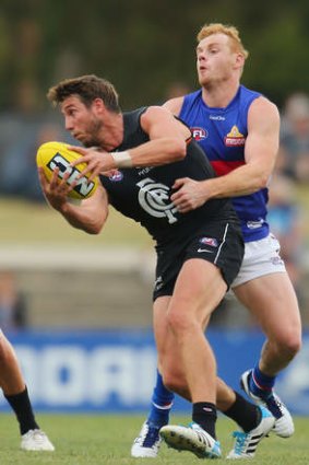 Daisy chained: Adam Cooney tackles Carlton's Dale Thomas.