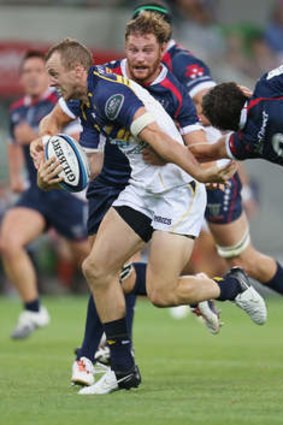 Jesse Mogg of the Brumbies beats the tackle by Nick Phipps.