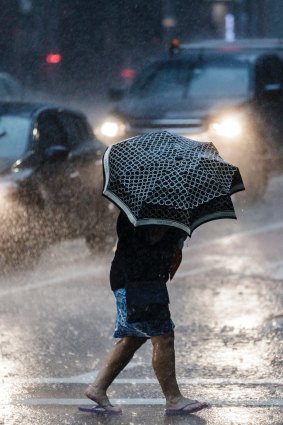 A pedestrian runs for cover after a storm hits Sydney.