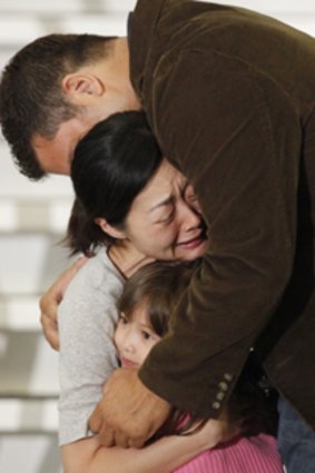 Emotional reunion  . . . Freed US journalist Euna Lin is welcomed home by her husband Michael Saldate and daughter Hana.