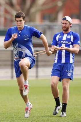 Lachlan Hansen holds back Scott Thompson during a North Melbourne training session on Wednesday.