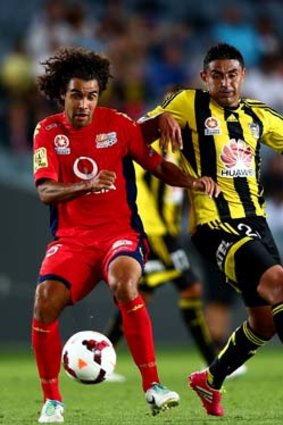 Osama Malik of Adelaide and Carlos Hernandez of the Phoenix tussle for the ball during the A-League match at Eden Park on Saturday.