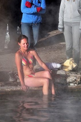 A tourist enters the water at a hot spring near the small village of Agua Brava on the salt flats.