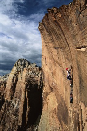 A rock climber at an overhanging sandstone wall, Zion National Park. 
