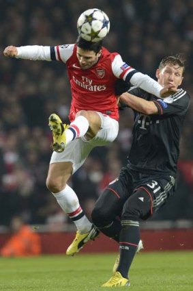 Arsenal midfielder Mikel Arteta (left) heads the ball under pressure from Bayern Munich midfielder Bastian Schweinsteiger.