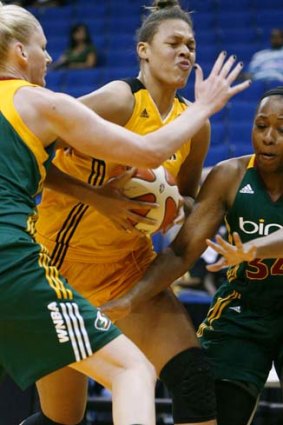 Playing for the Tulsa Shock, Liz Cambage tries to work between Seattle Storm's Lauren Jackson (left) and Le'Coe Willingham during a WNBA match in 2011.