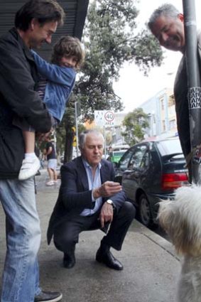 Going to the dogs ... Malcolm Turnbull takes photos of dogs on his campaign rounds in Bondi.