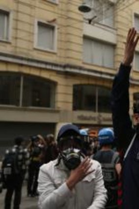 A masked policeman raises his arms in Istanbul's fashionable Istiklal Avenue during the anniversary protests.