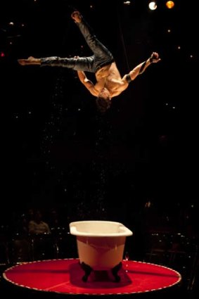 David O'Mer, "Bathboy", hangs above a bathtub at a media call performance for La Soiree at the Sydney Opera House.