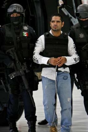 Jose Antonio Acosta Hernandez, 33, is escorted by federal police officers to a media presentation in Mexico City.