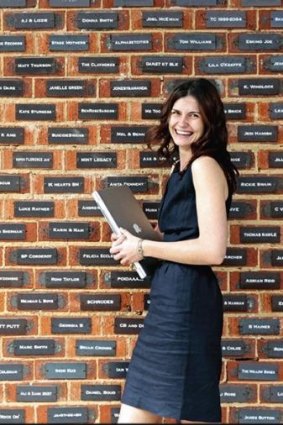 Amber Rooke, coordinator of the Annandale Hotel's 'Buy-a-Brick, Save the Dale' campaign with a wall of plaques bought by punters.