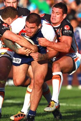 Russell Packer of the Warriors is tied up by the Tigers defence.