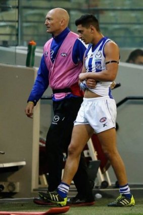 North Melbourne's Robin Nahas heads to the rooms with a suspected dislocated shoulder.