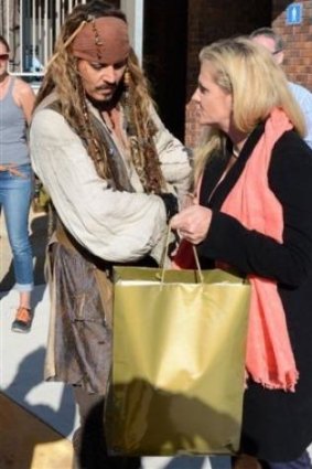 Redlands mayor Karen Williams presents Johnny Depp with a parting gift of local wares.