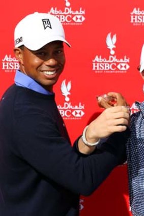 Tiger Woods and Rory McIlroy interlock arms while drinking coffee during a photocall before the start of the Abu Dhabi HSBC Golf Championship.