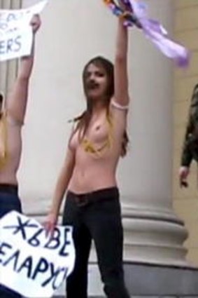 A second official arrives on the scene as members of Femen continue their demonstration.