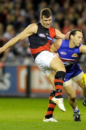 Bulldog Mitch Hahn (right) tries to spoil a kick on goal by Essendon's David Hille.