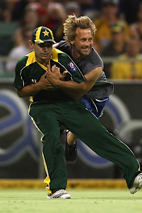 Forgettable night ... Khalid Latif is tackled by a spectator.