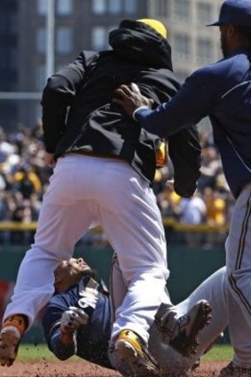 Pittsburgh Pirates' Travis Snider, left, takes down Milwaukee Brewers' Carlos Gomez.