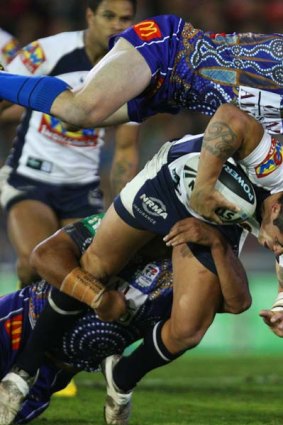 Corey Parker of the Broncos is tackled by Kurt Gidley of the Knights.