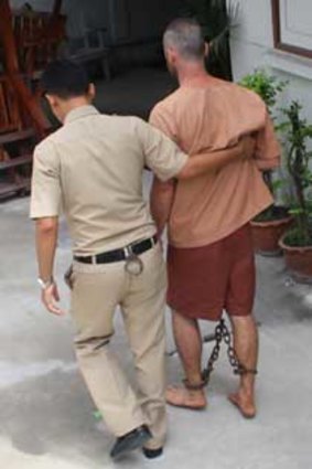 Conor David Purcell is escorted from court in Bangkok.