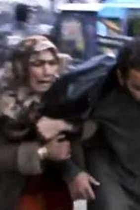 Air strike ... a man is helped from the bakery bombing.