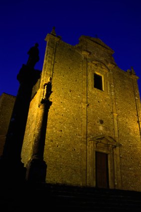 The 14th century abandoned monastery in Volterra lit up at night.