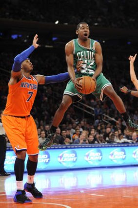 Boston's Jordan Crawford leaps next to New York Knicks forward Carmelo Anthony after getting fouled during the second half in New York. The Celtics won 114-73.
