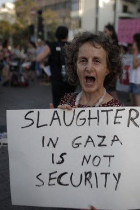 An Israeli activist carries a placard protesting against the bombardment of Gaza in the Israeli city of Tel Aviv.