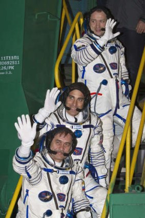 International Space Station crew members US astronaut Chris Cassidy (centre) and Russian cosmonauts Pavel Vinogradov (bottom) and Alexander Misurkin wave as they board the Soyuz TMA-08M spacecraft at the Russian-leased Baikonur cosmodrome.