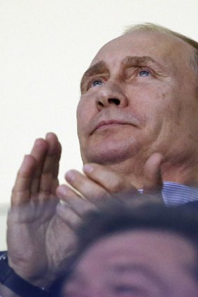 Russian President Vladimir Putin claps during the third period of a men's ice hockey game between the USA and Russia at the 2014 Winter Olympics.